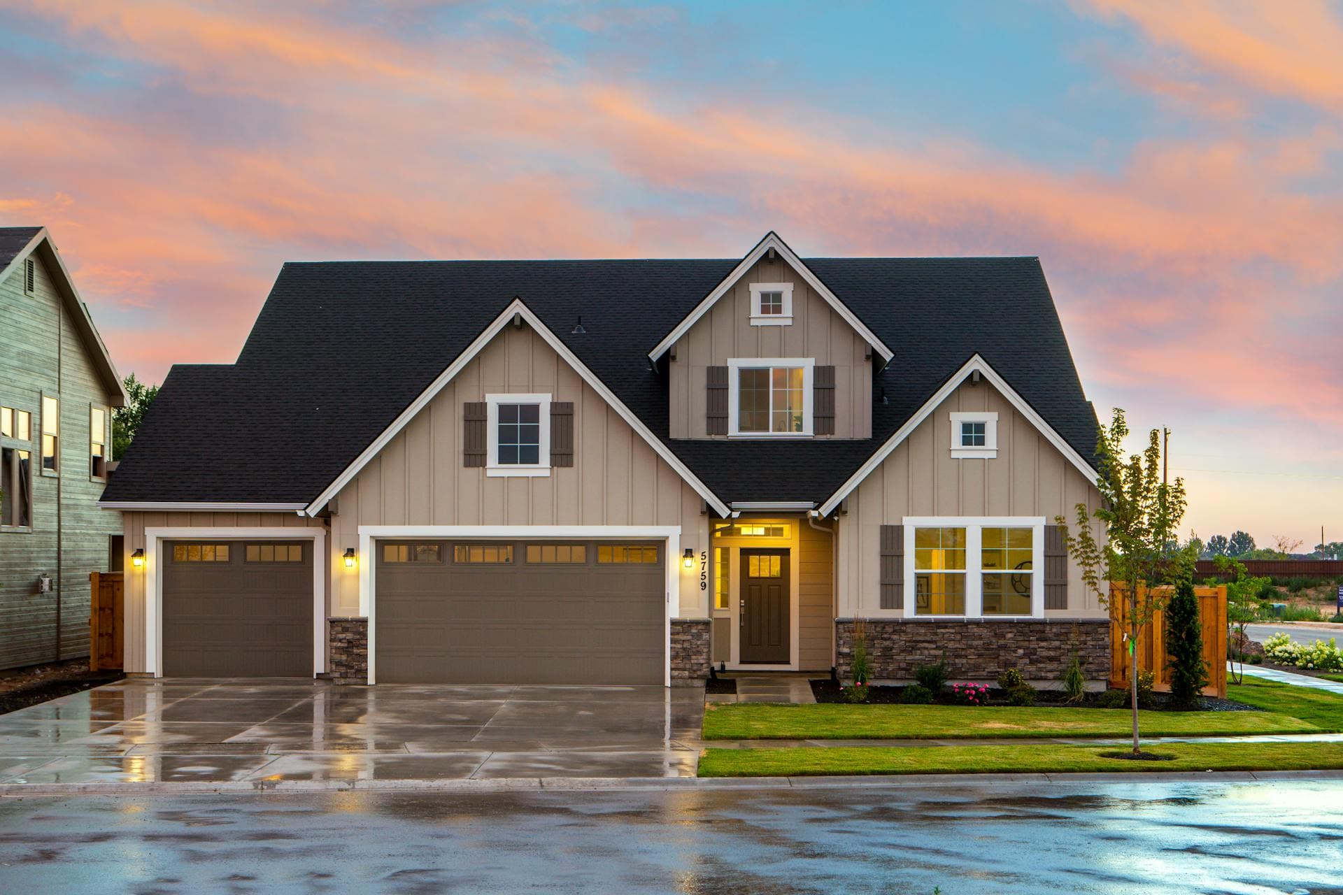 Modern carriage-style insulated garage doors on a Pacific Northwest farmhouse home in Vancouver, WA at dusk