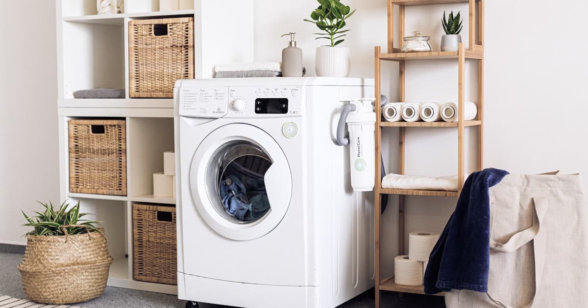 Modern laundry room with stacked washer and dryer, custom cabinetry, and quartz countertop in a Vancouver, WA home